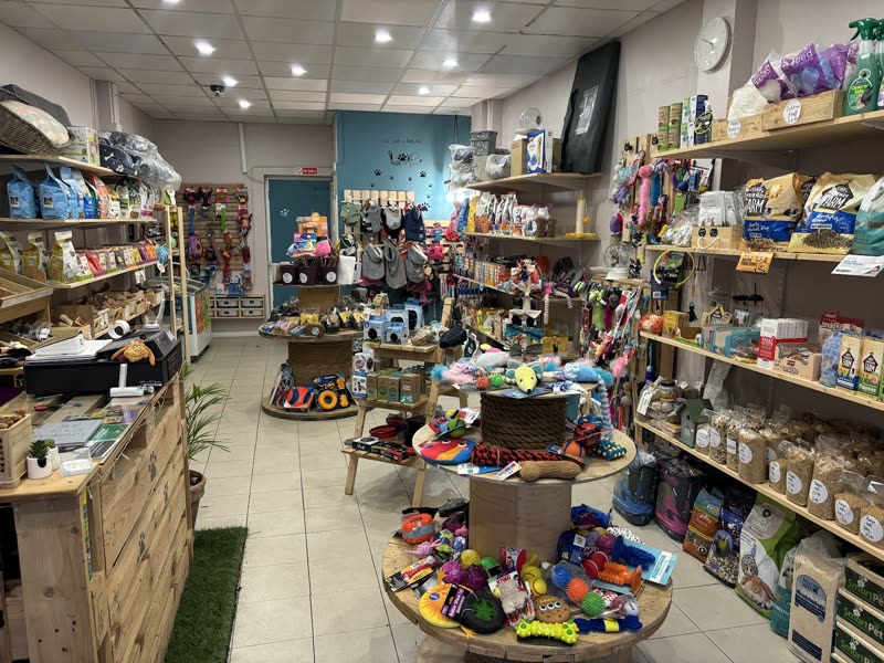 Inside T's Pets, looking down an aisle of wooden shelving stocked with pet food and treats